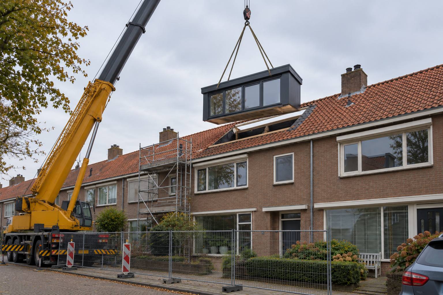 Prefab dakkapel die met een kraan op het dak van een rijwoning wordt gezet
