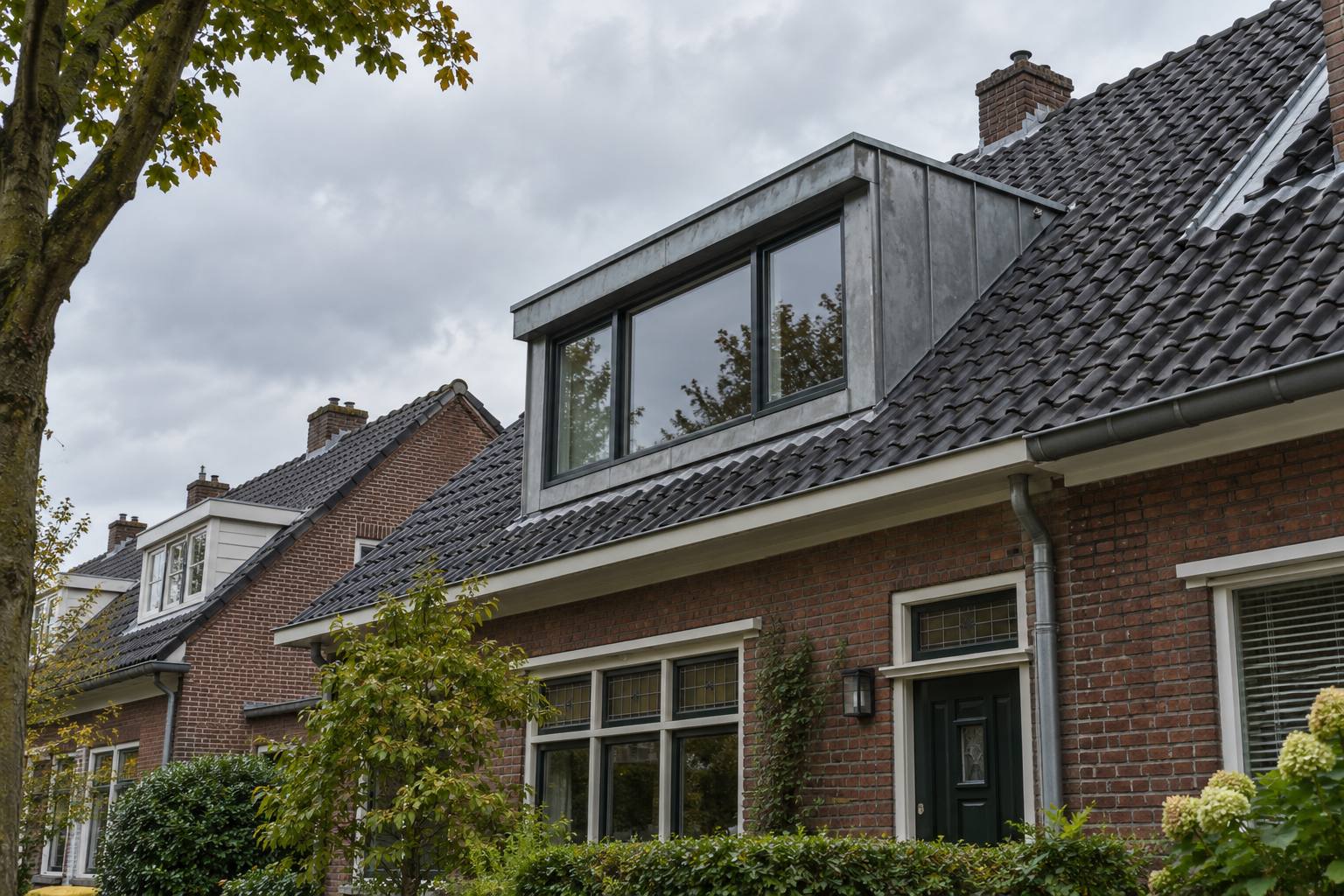 Zinken dakkapel met donkere kozijnen op een dak met antraciet pannen